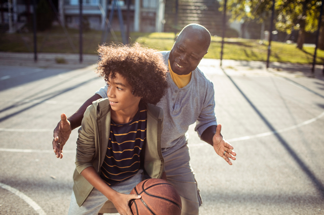 Grandpa and grandson having fun playing basketball