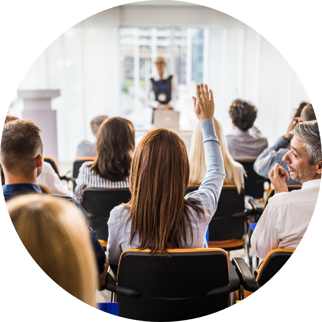 Young woman raising her hand in a seminar